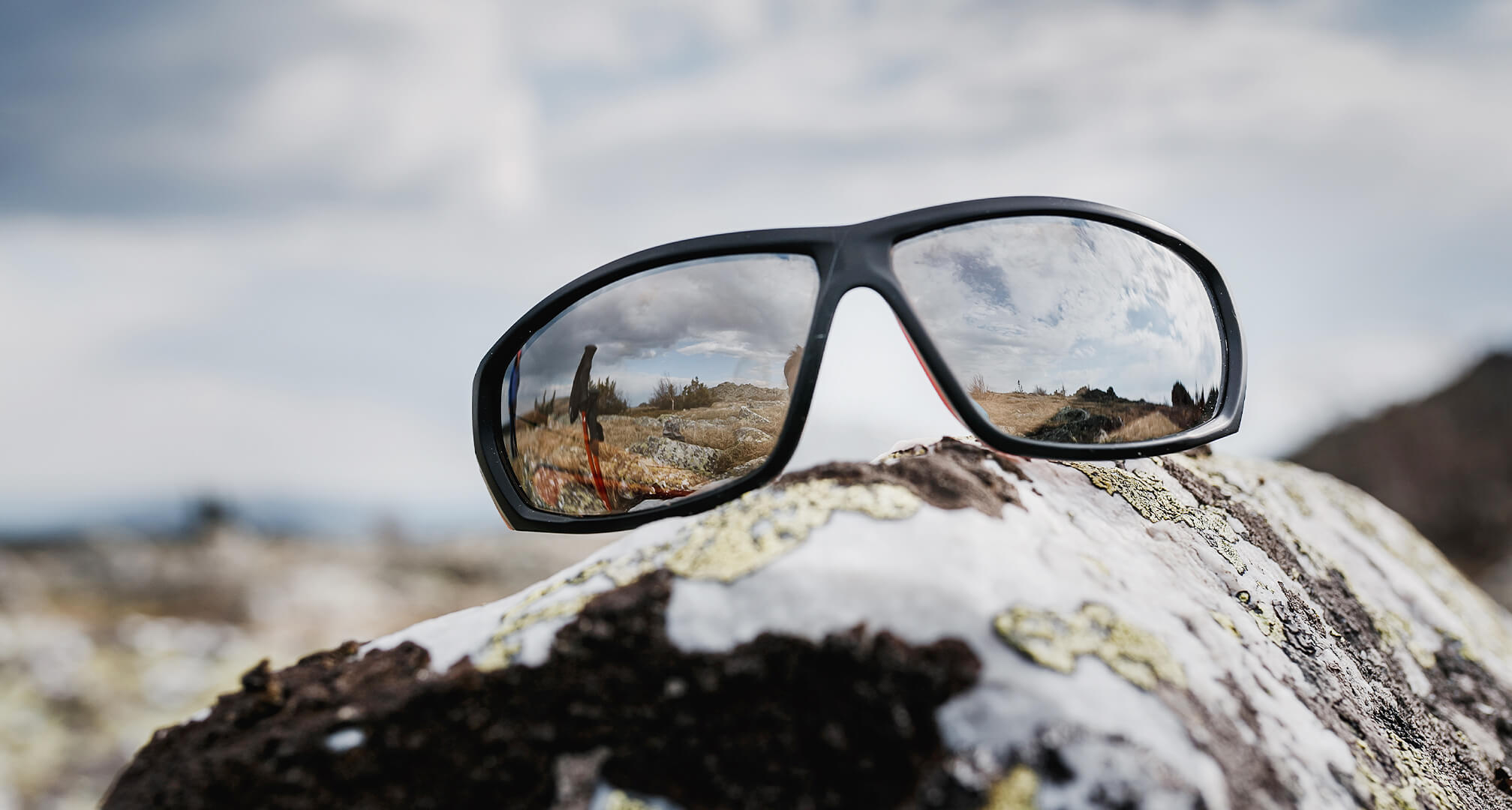 mirrored sunglasses sitting on rock